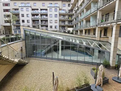 an external view of a building with a glass walkway at Bulwary Wiślane Kraków Apartament Ludwinowska przy Forum by Noclegi Renters in Kraków