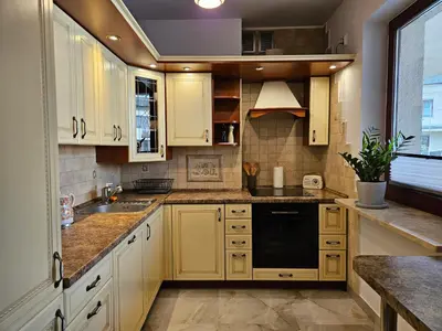 a kitchen with white cabinets and a black dishwasher at Bulwary Wiślane Kraków Apartament Ludwinowska przy Forum by Noclegi Renters in Kraków