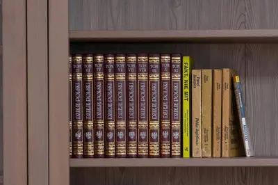 a row of books on a book shelf at Bulwary Wiślane Kraków Apartament Ludwinowska przy Forum by Noclegi Renters in Kraków