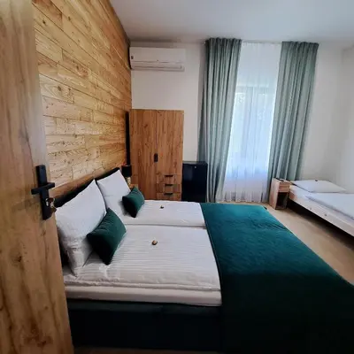 a bedroom with a large white bed with green pillows at Pokoje Izabela - Noclegi Graboszyce - Zator in Graboszyce