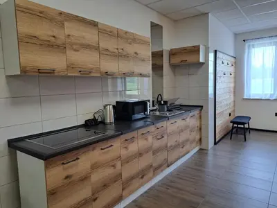 a kitchen with wooden cabinets and a black counter top at Pokoje Izabela - Noclegi Graboszyce - Zator in Graboszyce