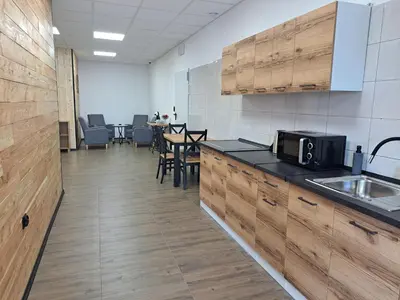 a kitchen with wooden cabinets and a table with chairs at Pokoje Izabela - Noclegi Graboszyce - Zator in Graboszyce