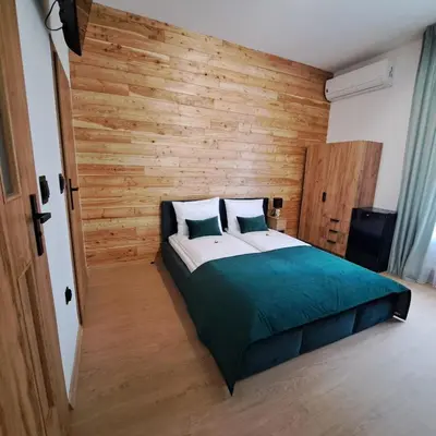 a bedroom with a large bed with wooden walls at Pokoje Izabela - Noclegi Graboszyce - Zator in Graboszyce