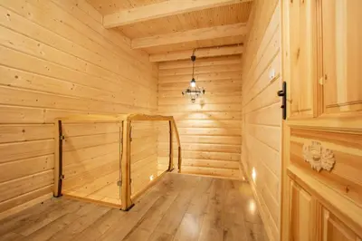 a wooden sauna with a wooden floor and a chandelier at Gorczański dom z bali w górach in Poręba Wielka