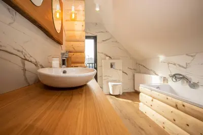 a bathroom with a white bowl sink and a tub at Gorczański dom z bali w górach in Poręba Wielka