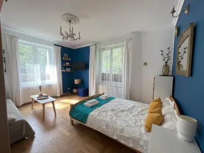 a bedroom with blue walls and a bed and a table at Greenthumb Praska in Kraków