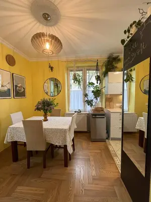 a dining room with a table and a kitchen at Greenthumb Praska in Kraków