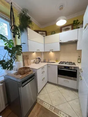 a kitchen with white cabinets and a stove top oven at Greenthumb Praska in Kraków