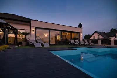 a house with a swimming pool and some chairs at Dom z jacuzzi do 10 osób Zator Willa LuxHouse in Zator