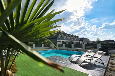 a patio with two chairs and a swimming pool at Dom z jacuzzi do 10 osób Zator Willa LuxHouse in Zator