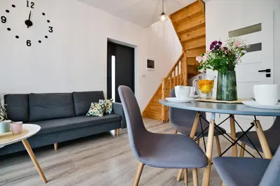 a living room with a table and a couch at Domki na Sosnowej by Housine in Zator