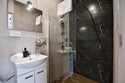 a bathroom with a sink and a shower at Domki na Sosnowej by Housine in Zator