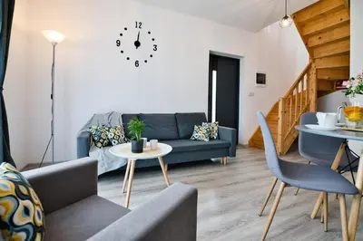 a living room with a blue couch and a table at Domki na Sosnowej by Housine in Zator