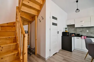 a small kitchen and staircase in a tiny apartment at Domki na Sosnowej by Housine in Zator