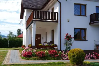 a white house with flowers in front of it at Willa Tulipan in Kamienica
