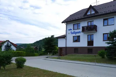 a building with a sign for a hotel at Willa Tulipan in Kamienica