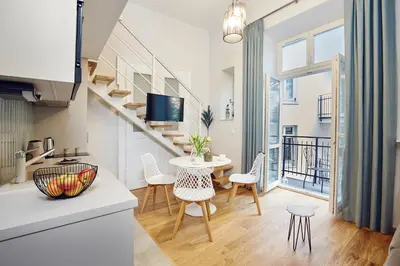 a kitchen and living room with a table and chairs at Pola Apartament Old Town - Kazimierz in Kraków