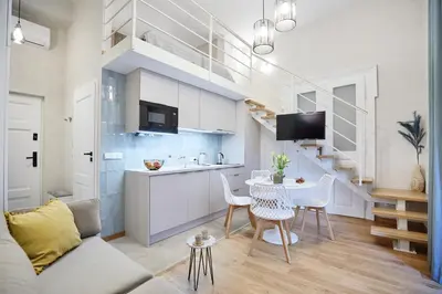 a kitchen and living room with a table and chairs at Pola Apartament Old Town - Kazimierz in Kraków