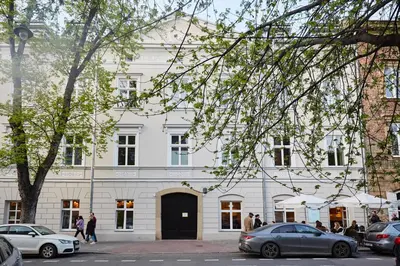 a white building with cars parked in front of it at Pola Apartament Old Town - Kazimierz in Kraków