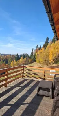 a bench sitting on a porch next to a fence at Gładyszówka - Chatka w Gorcach in Ponice