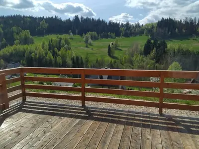 a wooden bench sitting on top of a wooden deck at Gładyszówka - Chatka w Gorcach in Ponice