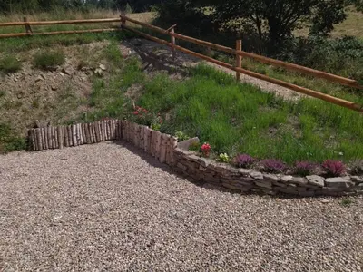 a rock garden with flowers and a fence at Gładyszówka - Chatka w Gorcach in Ponice