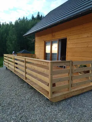 a large wooden cabin with a large porch at Gładyszówka - Chatka w Gorcach in Ponice
