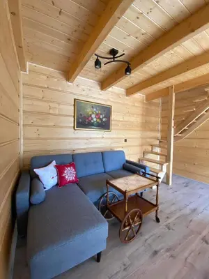 a living room with a blue couch and a table at Gładyszówka - Chatka w Gorcach in Ponice