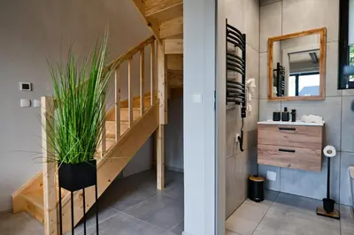 a bathroom with a staircase leading up to a loft at Domki na Wiśniowej Zator in Zator