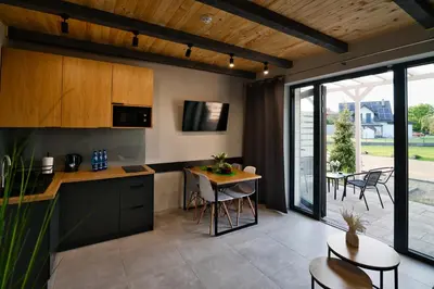 a kitchen and dining room with a table and chairs at Domki na Wiśniowej Zator in Zator