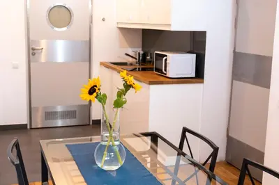 a vase with flowers on a glass table in a kitchen at Sewa Apartments in Kraków