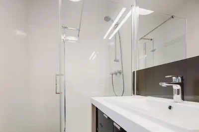 a bathroom with a sink and a shower and a mirror at Sewa Apartments in Kraków