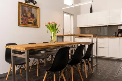 a dining room table with black chairs and a vase of flowers at Sewa Apartments in Kraków