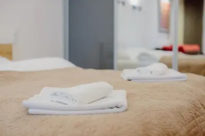 two white towels sitting on top of a bed at Sewa Apartments in Kraków