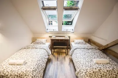two beds in a room with a window at Sewa Apartments in Kraków