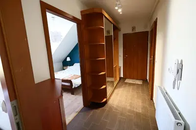 a room with a staircase and a bedroom with a mirror at Rabczański Apartament in Rabka-Zdroj