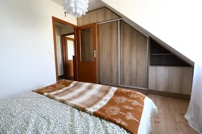 a bedroom with a bed and wooden cabinets at Rabczański Apartament in Rabka-Zdroj