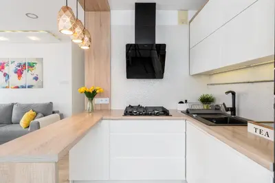 a kitchen with white cabinets and a stove at Sunny Kliny Apartment in Kraków