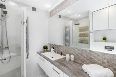 a bathroom with a sink and a shower at Sunny Kliny Apartment in Kraków