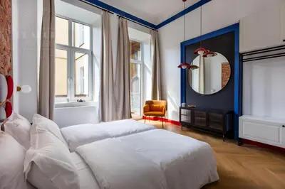 a bedroom with a large white bed and a mirror at Spacious City Center Family Apartments in Kraków