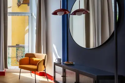 a living room with a mirror and a chair at Spacious City Center Family Apartments in Kraków
