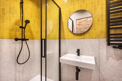 a bathroom with a shower and a sink and a mirror at Spacious City Center Family Apartments in Kraków