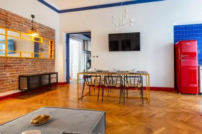 a dining room with a table and a red refrigerator at Spacious City Center Family Apartments in Kraków