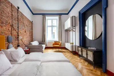 a bedroom with a large bed and a brick wall at Spacious City Center Family Apartments in Kraków