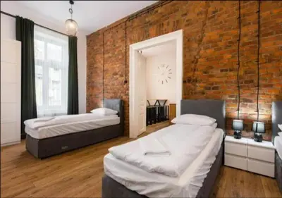 a bedroom with two beds and a brick wall at Spacious City Center Family Apartments in Kraków