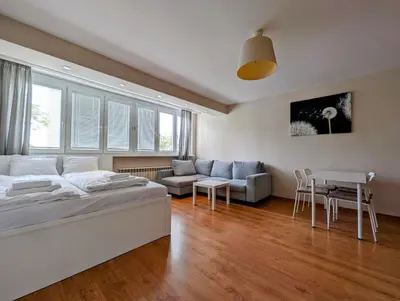 a bedroom with a bed and a living room at Kazimierza Wielkiego 87 by Homeprime in Kraków