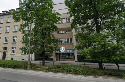 a building on the side of a street with trees at Kazimierza Wielkiego 87 by Homeprime in Kraków