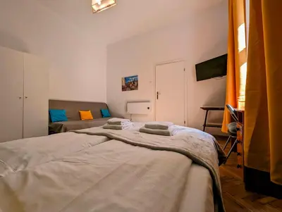a bedroom with two beds and a television in it at Wiślna 4 by Homeprime in Kraków