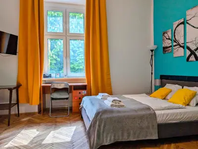 a bedroom with a bed and a desk and a window at Wiślna 4 by Homeprime in Kraków