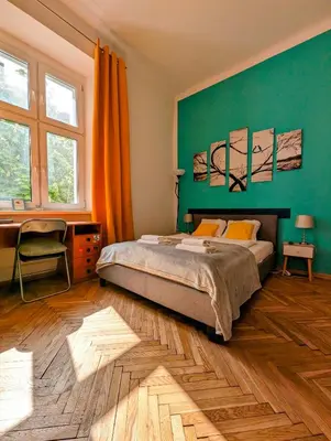a bedroom with a bed and a green wall at Wiślna 4 by Homeprime in Kraków